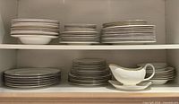 Stacks of plates and gravy boat on shelves