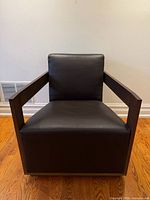 Front view of dark brown leather and wood lounge chair