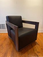 Front angled view of chair showing leather upholstery and wood frame