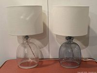 Front view of both lamps showing clear and grey bases with shades