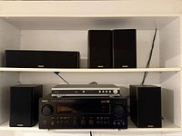 Front view of receiver, DVD player and five speakers on shelving