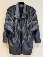 Front view of dark grey embroidered leather coat hanging