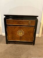 Front view showing drawer, cabinet doors, brass hardware, overall finish