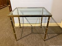 Three-quarter view of the brass and glass side table