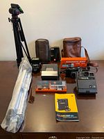 Overview of all items on table including tripods, cameras, flash and accessories