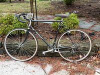 Full left-side view of black Nishiki road bicycle showing frame, wheels and components
