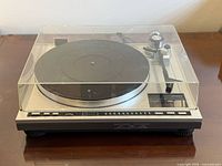 Front angled view of Onkyo CP-1028R turntable with dust cover in place