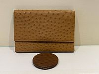 front view of ostrich leather clutch with matching compact