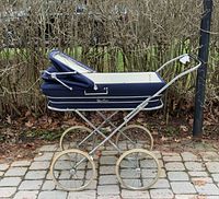 Side view of navy Silver Cross pram showing full carriage and wheels