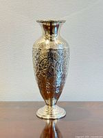 Full view of silver-plated vase standing upright
