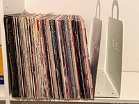 Shelf view of entire grouping of vinyl LPs with metal stand