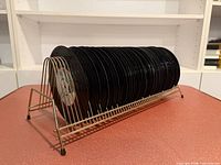 Side view of brass-tone wire rack filled with 45 RPM records