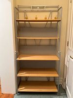 Full front view of metal-framed shelving unit with five wood shelves