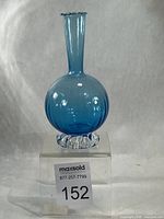full front view of turquoise bud vase on stand