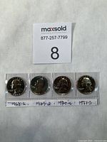 Obverse side of four Washington proof quarters in plastic strip labeled with years