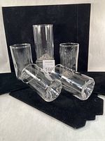 Group shot of five Mt. Rainier pint glasses, some upright and some on their sides showing mountain relief bases