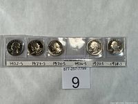 Front view of five proof quarters in plastic strip labeled by year