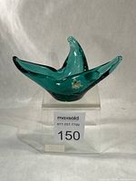 Front view of teal green pulled style glass dish on display block, maple leaf foil sticker visible