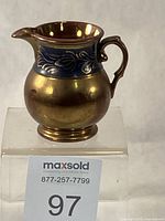 Front view of copper lustre jug on stand