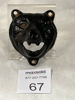 Front view of cast iron bear head bottle opener showing mounting holes and mouth