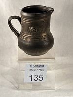 Front view of copper-lustre stoneware creamer