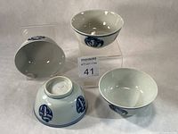Four rice bowls showing exterior crane medallion and interior glaze
