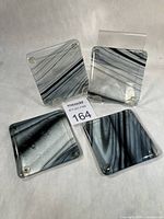 Top view of all four fused glass coasters showing patterns and feet