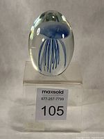 Front view of glass jellyfish paperweight on display stand
