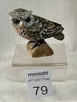Front view of owl figurine on clear stand with lot number