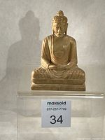 Front view of the entire Buddha statue on clear riser
