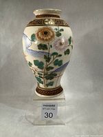 Full view of vase on stand showing overall shape and decoration