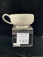 Full side view of mug on stand showing overall form and condition