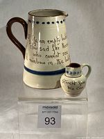 Large and small Torquay Motto Ware jugs front view with mottos visible