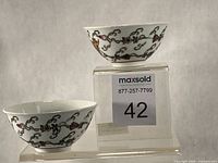 two matching porcelain butterfly bowls on display stand