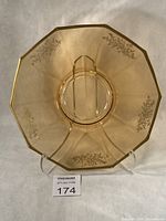 Front view of amber decagon platter showing gold floral encrustation and overall form