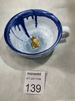 Top view showing interior white glaze, blue drips, and 3-D cat figurine