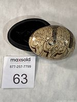 Trinket box opened showing lid with painted figures and black interior