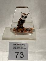 Front view of lucite paperweight showing owl figurine and granite base