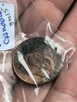 Obverse of copper token in bag, showing bust portrait and 1867-1927 legend