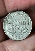 Reverse of 1930 Canada 5 cent coin showing denomination, maple leaves and date