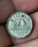 Reverse of 1947 Canadian 5-cent coin showing beaver, maple leaf beside date