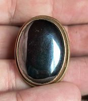 Front view showing large oval hematite cabochon in bronze bezel