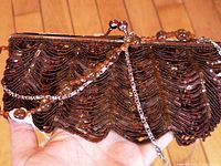 Front view of brown beaded clutch, straps visible