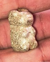 Front view of small pewter gummy bear figurine showing textured surface