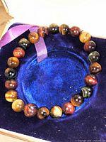 Bracelet on blue velvet pad showing full circle of tiger's eye beads