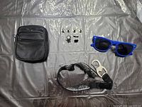 All items laid out: leather pouch, sunglasses, lanyard with bottle opener, six metal snaps