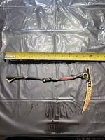 Full view of assembled scythe with tape measure showing length