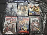 Front view of six movie cases: Abduction, Gangs of New York, The Greatest Showman, School of Rock, Dragons: Fire & Ice, Shaun of the Dead