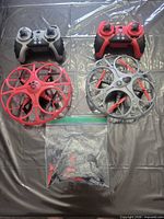 Top view of two drones with corresponding controllers and bag of spare propellers