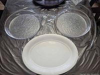 Two clear round glass platters and one white oval ceramic platter on table